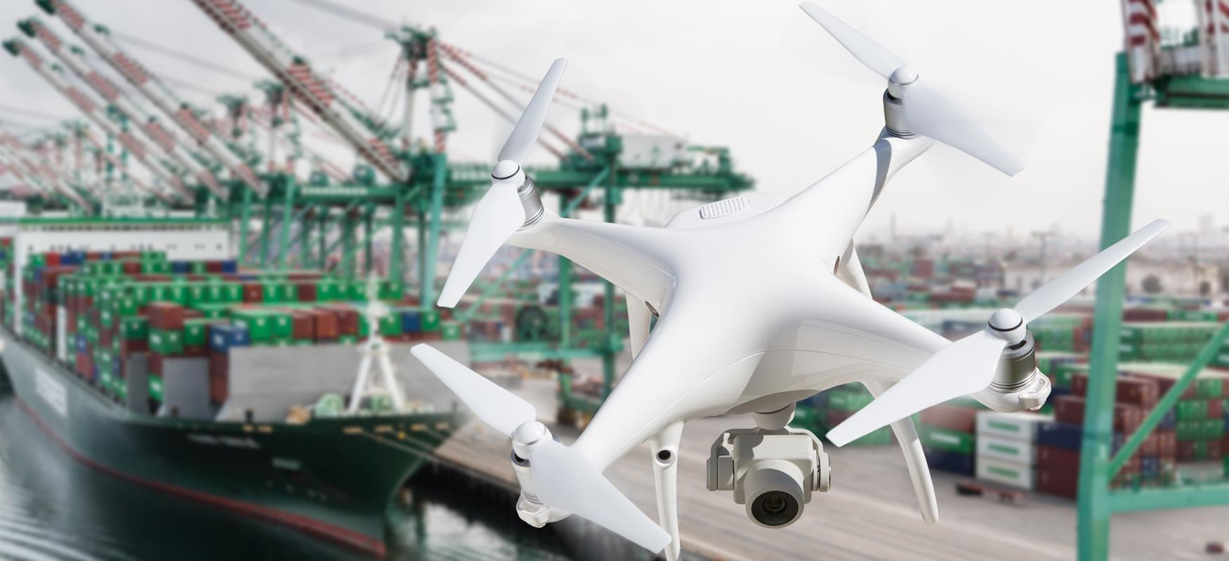 A drone flying over a harbor with large container ships in the background.