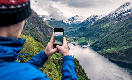 mand tager billede af fjell med sin telefon
