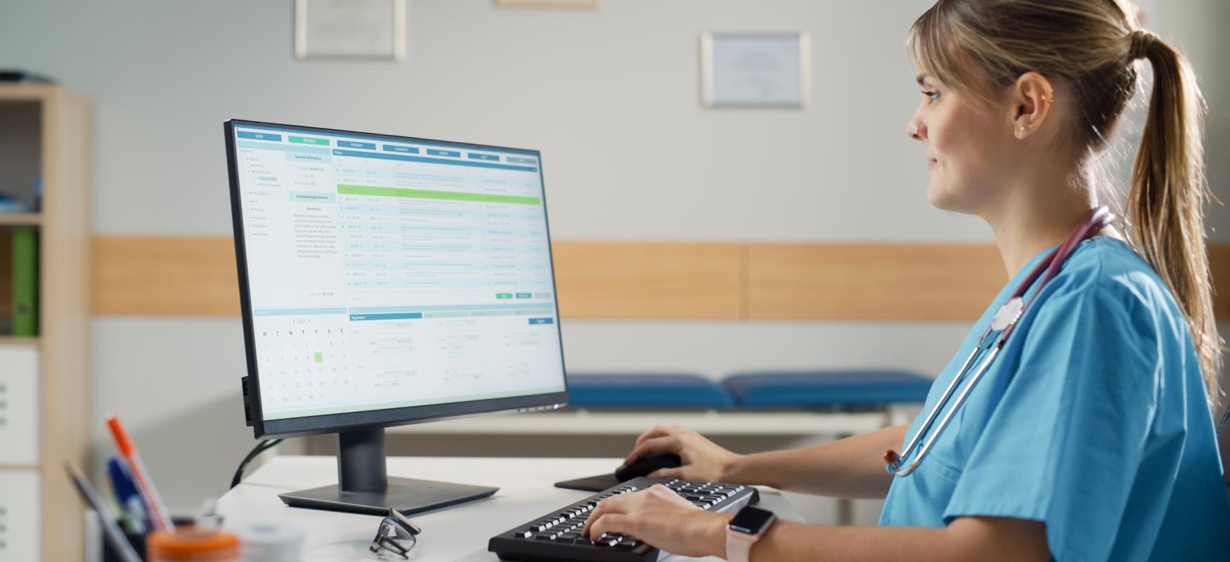 Læge sidder ved computer