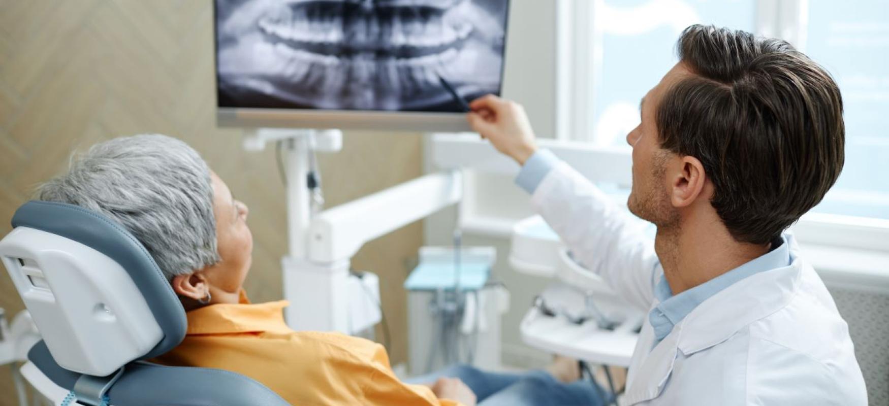 Helsepersonale kigger på et røntgenfotografi sammen med en patient