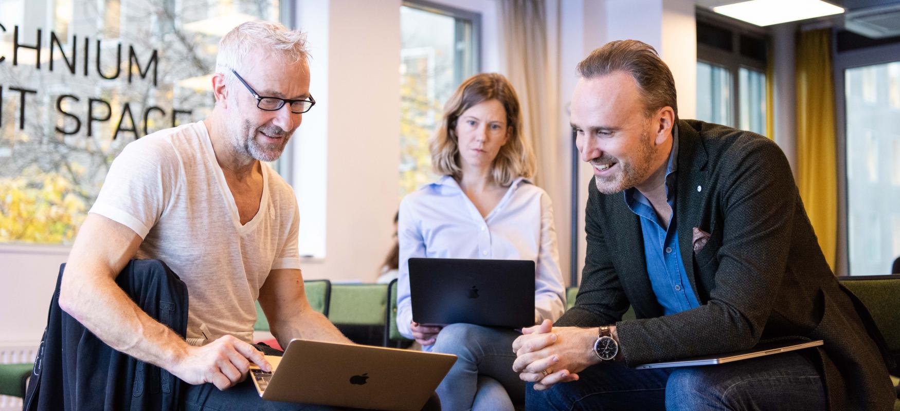 Three participants from batch 3 of Nordic Scalers in front of a computer.