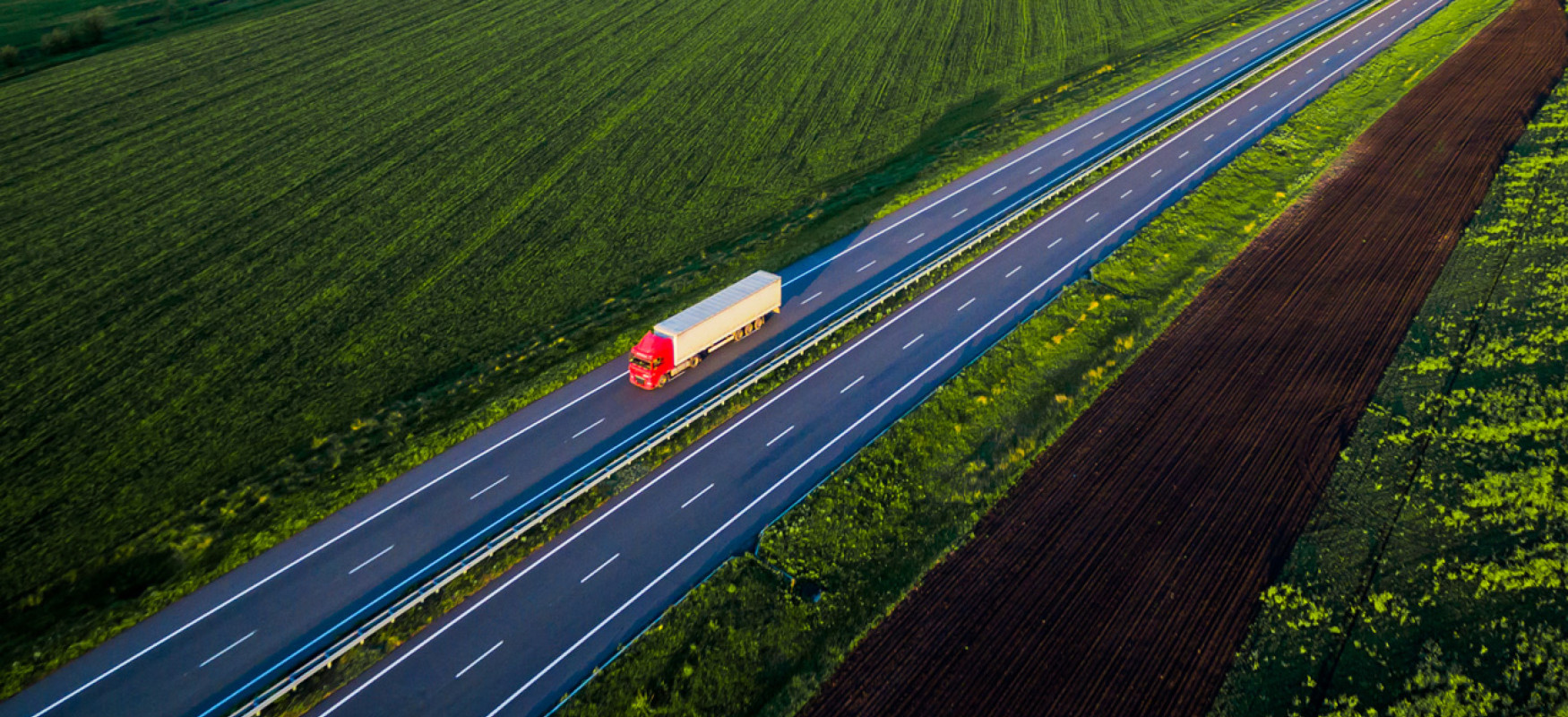 Birdzs view of red truck driving across green fields