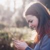 Healty woman using a smartphone in the woods. 