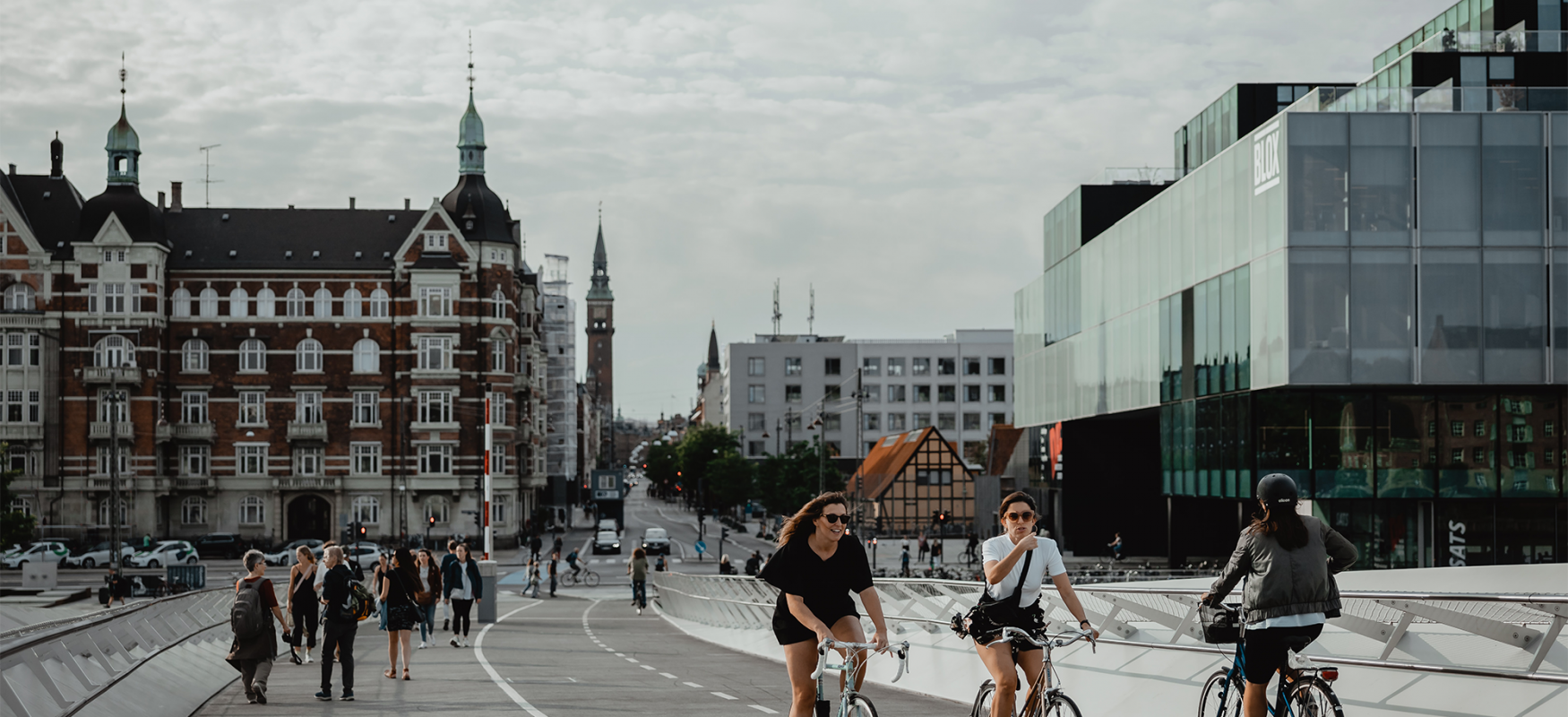 two women biking across a bridge in Copenhagen